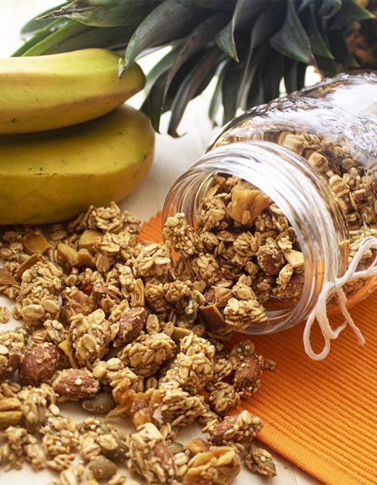 Granoa exótica Nutrisnacks en frasco de vidrio acompañado de piña y bananos