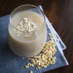 Bebida refrescante de avena servida en un vaso sobre un mantel azul