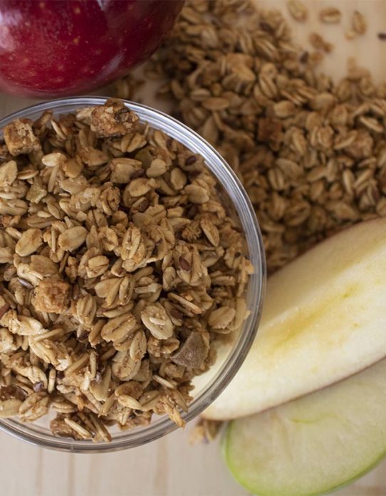 Granola manzana y canela Nutrisnacks en bowl de vidrio con trozos de manzana